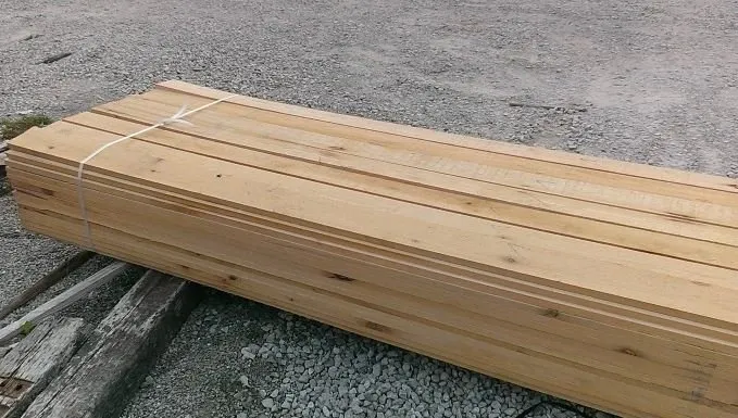 Stack of wooden planks on gravel