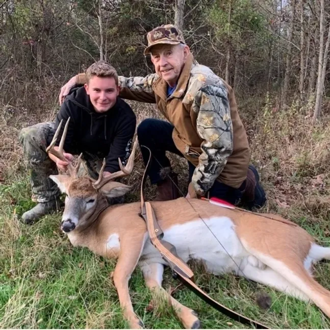 Hunters posing with a deer